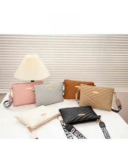 Vue détaillée de petits sacs à bandoulière rectangulaires avec matelassage en V et sangle