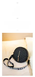 Detail of black round crossbody bag with V-quilted texture and elegant gold tassel