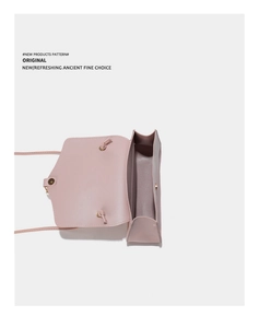 Detailed top view of light pink leather crossbody bag with flap closure and main compartment