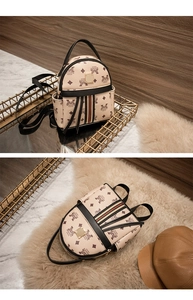 Detail of mini beige backpack with letter prints and decorative red and green straps