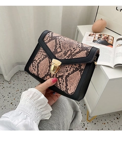 Detail of pink snake print crossbody bag with gold metallic twist lock and black trim