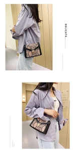 Detail of snake print crossbody bag with gold buckle lock and chain strap on model