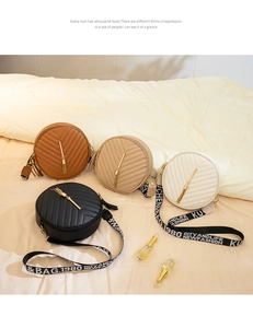 Close-up of V-quilted circular crossbody bags with gold tassels and lettered straps