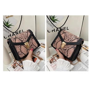 Detail of snakeskin textured crossbody bag with gold lock and metal chain strap
