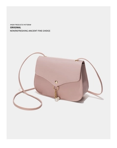 Detail of pink mini crossbody bag with gold snap closure and double pearl pendant charms