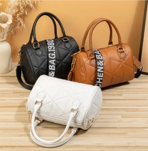 Détails de texture matelassée et bandoulières à motifs sur sacs Boston cylindriques