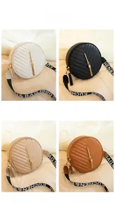 Detail of round quilted crossbody bags with V-pattern, tassel accents and wide straps