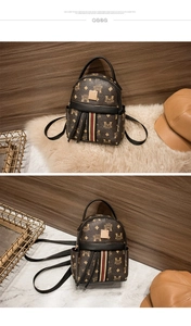 Detail of vintage monogram backpack with tricolor stripe and gold buckle on marble background