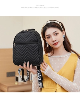 Detail of black quilted school backpack with V-pattern and embroidered webbing handle