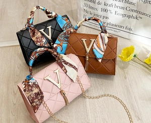 Quilted crossbody bags with V-shaped metal hardware, tassels, and scarf handles