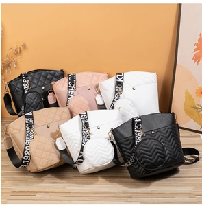 Quilted bucket handbags in multiple colors with wide logo straps and round coin purses