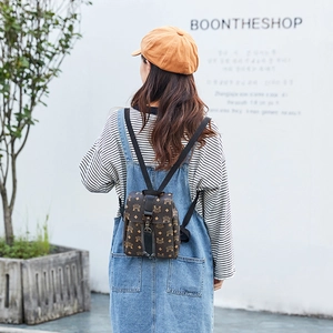 Mini brown leather backpack with classic monogram print and flap closure on model
