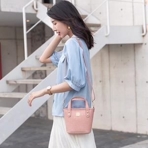 Elegante bolso de cubo rosa con grabado de cocodrilo y detalles dorados de mujer