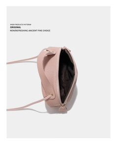 Vue de dessus du sac bandoulière rose en cuir grainé montrant l'intérieur zippé