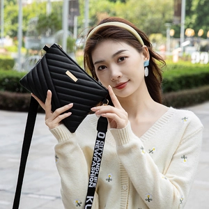 Sac bandoulière noir matelassé avec fermoir doré et bandoulière large imprimée sport