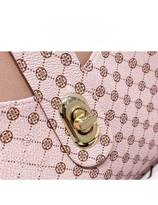 Détail d'un sac à main en cuir rose grainé avec imprimé et fermoir métallique doré rotatif