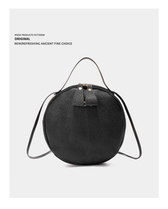 Détails du sac bandoulière rond noir avec texture grainée et double fermeture éclair
