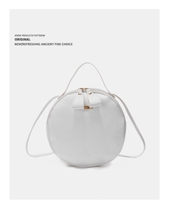 Détail du sac à main rond blanc avec texture litchi et fermetures éclair dorées