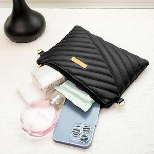 Petit sac à bandoulière noir matelassé avec détails dorés montrant sa grande capacité