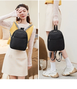 Detail of black mini nylon backpack with chevron quilting and sporty lettered straps