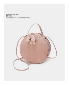 Détail du sac bandoulière rond en cuir grainé rose clair avec fermetures dorées