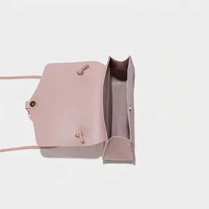 Minimalist light pink crossbody handbag for women in a sleek synthetic leather finish