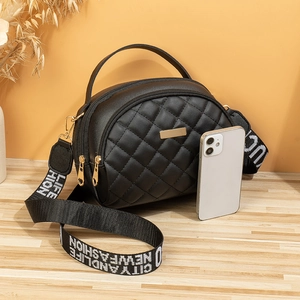 Sac à main demi-lune noir matelassé avec fermetures dorées et bandoulière large