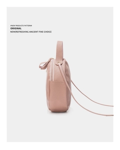 Vue détaillée du sac bandoulière en cuir rose avec poignée ronde et fermeture