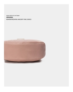 Détail du fond arrondi et des coutures soignées sur le sac en cuir rose clair grainé