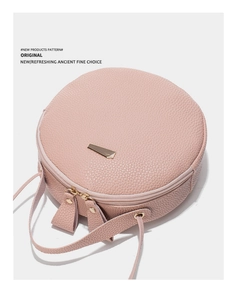 Vue de dessus du sac bandoulière rond rose avec texture litchi et détails dorés