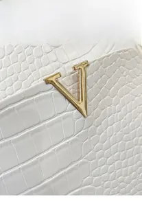 Close-up of white crocodile pattern faux leather backpack with golden V-shaped hardware