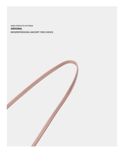 Détail de la bandoulière en cuir rose du sac avec des coutures fines et une boucle métallique