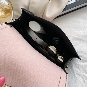 Pink and black contrast crossbody bag showing spacious interior with cosmetics