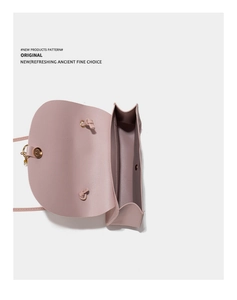 Detail view of pink leather crossbody bag showing inner compartment and gold hardware