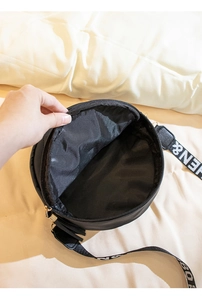 Detail view showing the spacious interior and zipper closure of the round embroidered bag