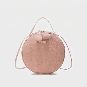 Sac bandoulière rond rose à texture litchi avec poignée et fermetures dorées