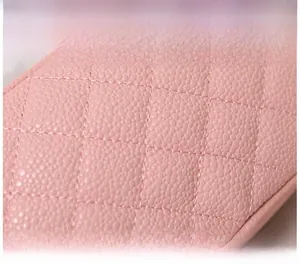 Gros plan d'un sac en cuir rose matelassé avec surpiqûres en losange et texture grainée