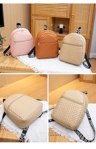 Detail of trendy V-quilted mini backpacks with decorative lettered straps in soft colors