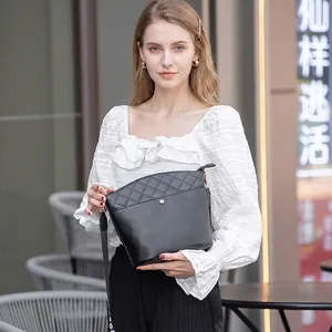 Chic black quilted bucket bag for women with wide fabric strap and gold buckle