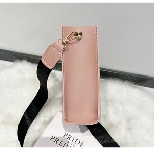 Détail du sac seau en cuir rose clair avec sangle noire et crochets en métal doré