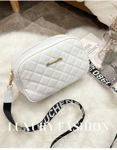 Close-up of white quilted PU leather crossbody bag with logo and jacquard strap