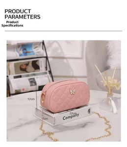 Sac bandoulière rose matelassé avec chaîne dorée et logo papillon en détail