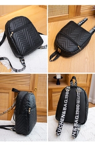 Detail view of black mini backpack with V-quilt pattern and logo wide shoulder strap