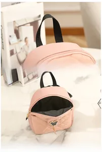 Detail of pink quilted backpack showing the comfortable handle and Disney-style metal logo