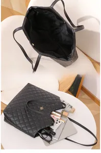 Internal view of large black quilted tote bag showing spacious capacity for laptops and items