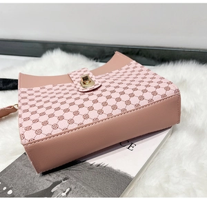Détail du sac bandoulière en cuir rose et beige avec monogramme et fermoir doré