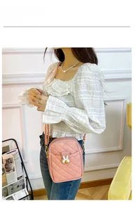 Detailed view of pink quilted PU leather crossbody bag featuring a white rabbit metal clasp