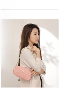 Sac bandoulière matelassé rose chic avec boucle papillon blanche et chaîne dorée élégante