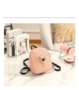 Pink quilted faux leather mini backpack with bear charm and detailed size parameters