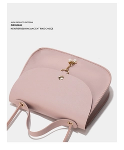 Close-up of pink PU leather handbag with golden pearl chain and metal buckle detail